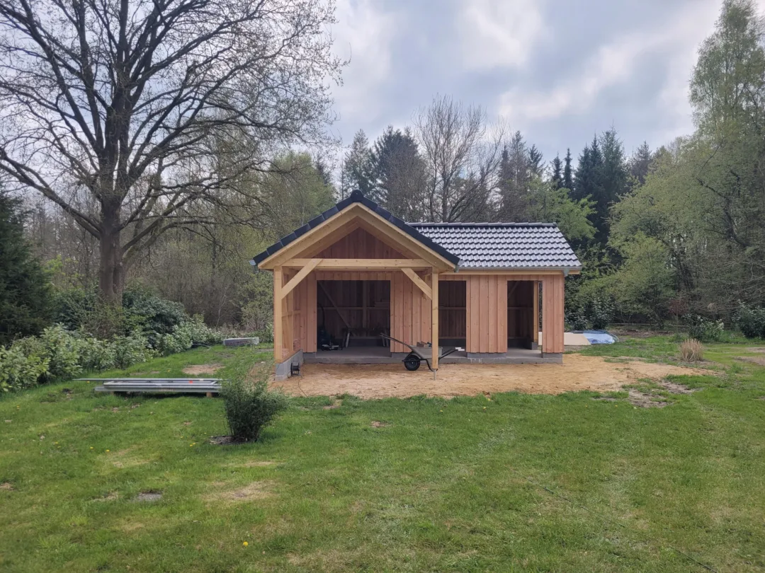 Fertiger Carport mit Geräteraum aus Lärchenholz, Satteldach mit schwarzen Dachsteinen