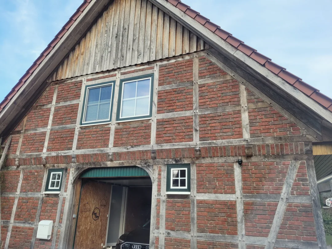 Fachwerkgiebel mit rotem Klinker und Holzverschalung im Giebeldreieck